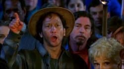 Rob Schneider as the Townie character from The Waterboy, standing in the crowd with an intense excited expression and mouth open, yelling encouragement during a football game