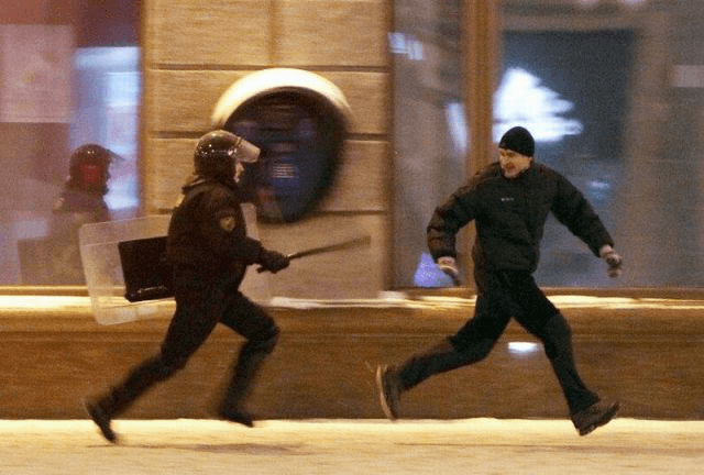 Man Running From Riot Police