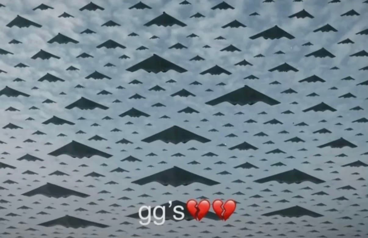 A cloudy gray sky crowded with dozens of dark, triangular B-2-style stealth bombers flying in formation, with larger aircraft in the foreground and the text “gg’s” followed by two broken-heart emojis near the bottom center.