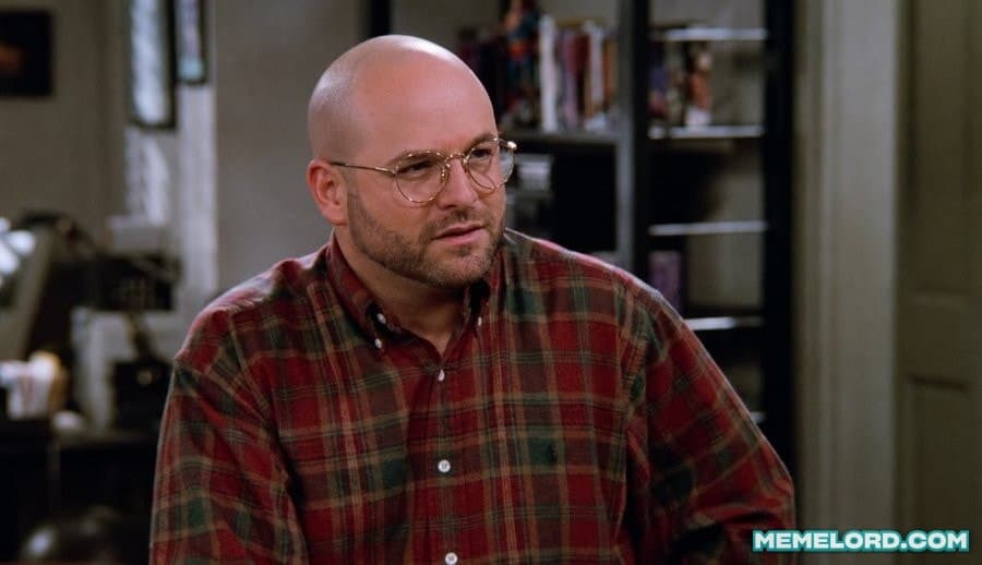 A bald man wearing round glasses and a red plaid shirt looks skeptically to the side in a home interior; a MEMELORD.COM watermark appears at the lower right.