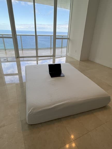 Laptop on a mattress in an oceanfront apartment (removed bg)