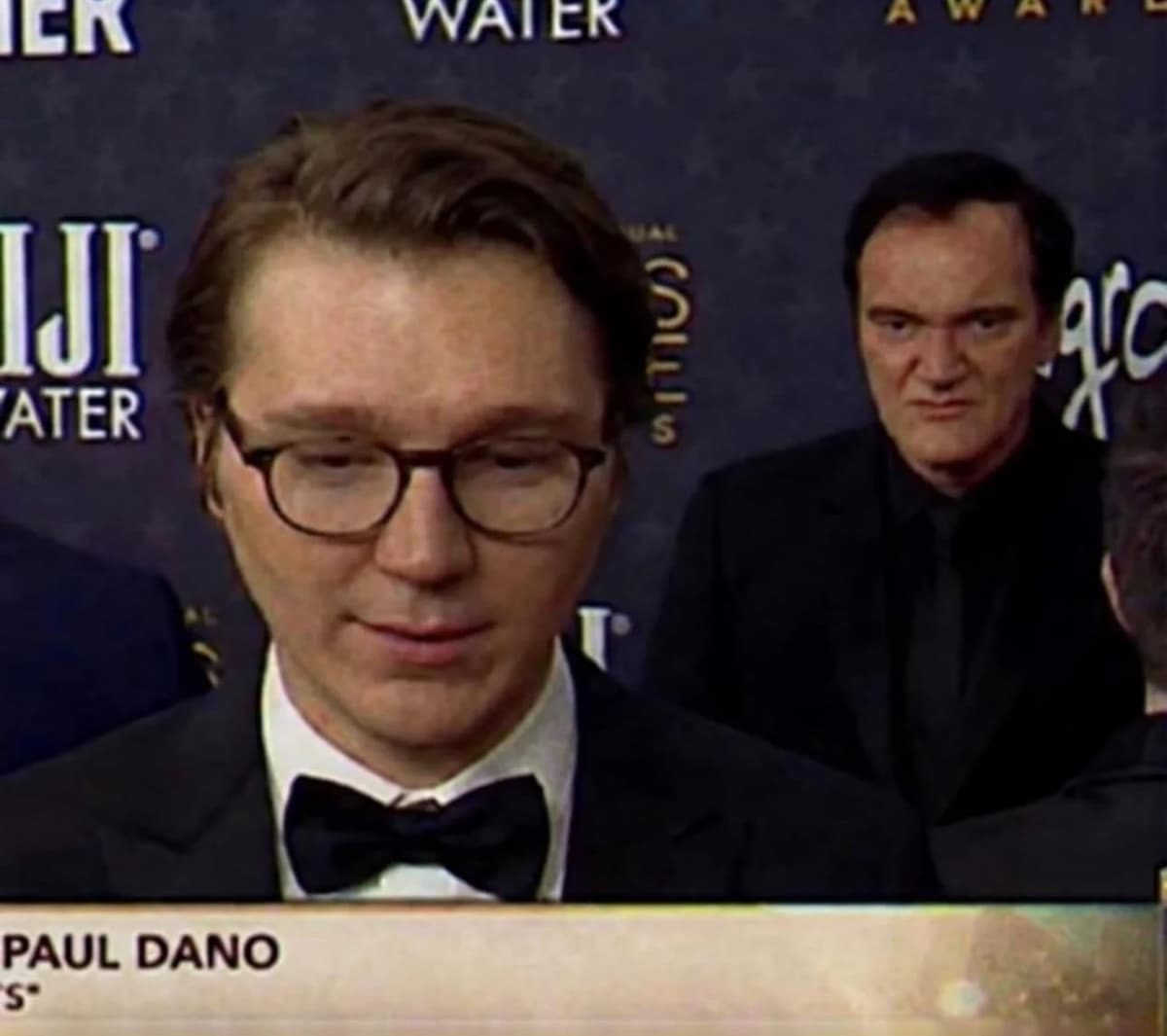 Quentin Tarantino intensely staring at Paul Dano from behind
